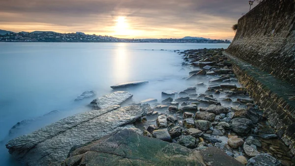 Denizin üzerinde gün batımı Taşlarla