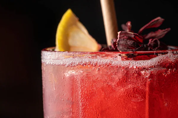 Kırmızı kokteyl. Limon ve samanla kapat.