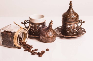 İki fincan çay tabağı, bakır ve porselenden yapılmış. Doğu stili bir tezgah. Plastik beyaz bir arka planda.. 