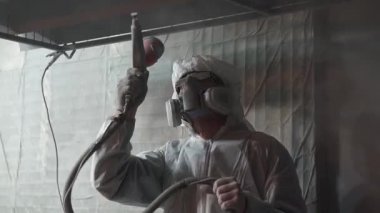 Toz kaplama. Sprey tabancalı adam metal nesnelere toz uyguluyor..