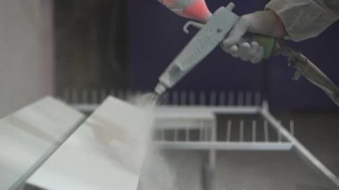 Toz kaplama. Sprey tabancalı adam eli metal nesneye pudra uygular.