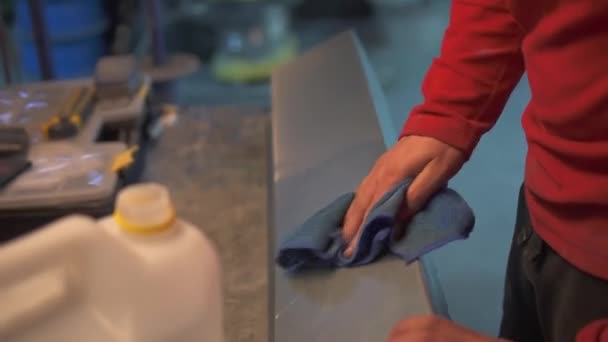 The workers hand wipes the metal product with a cloth with a degreaser — Stock Video