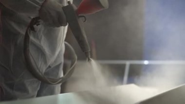 Toz kaplama. Sprey tabancalı adam metal nesnelere toz uyguluyor..
