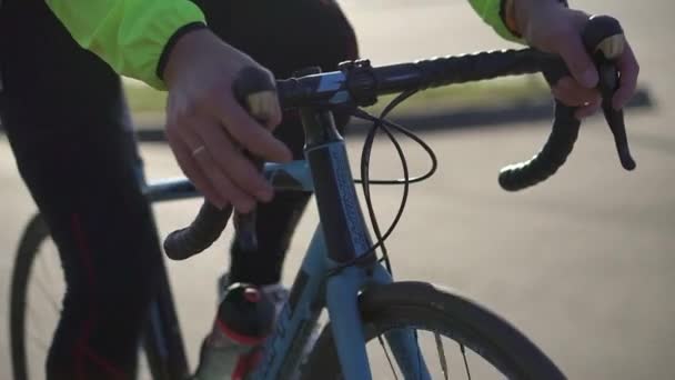 De fietsers handen houden het stuur vast, zijn voeten draaien de pedalen — Stockvideo