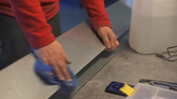 Los trabajadores limpian a mano el producto metálico con un paño con un desengrasante — Vídeo de stock