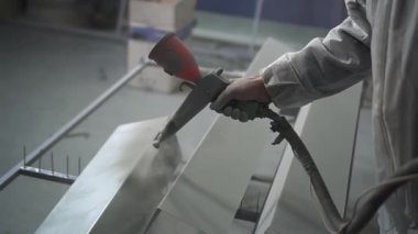 Toz kaplama. Sprey tabancalı adam eli metal nesneye pudra uygular.
