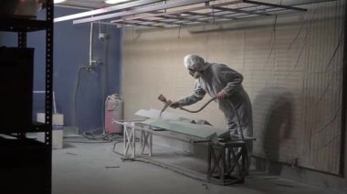 Toz kaplama. Sprey tabancalı adam metal nesnelere toz uyguluyor..