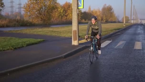 Rowerzysta jeździ na rowerze o świcie. trening przed zawodami triathlonowymi — Wideo stockowe