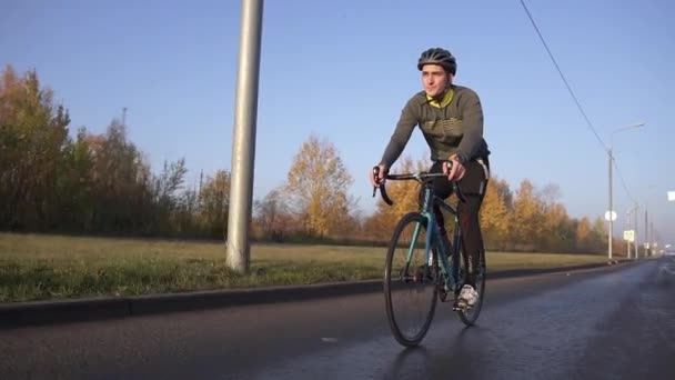 Rowerzysta jeździ na rowerze o świcie. trening przed zawodami triathlonowymi — Wideo stockowe