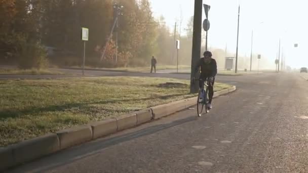 Cyclist rides on road bike at dawn. training before triathlon competition — Stock Video