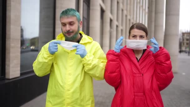 Freund und Mädchen setzten Masken in der Nähe des Gebäudes auf — Stockvideo