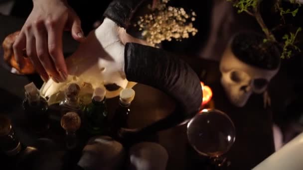 Ülés a fekete mágia a koponya egy kecske gyertyafény — Stock videók