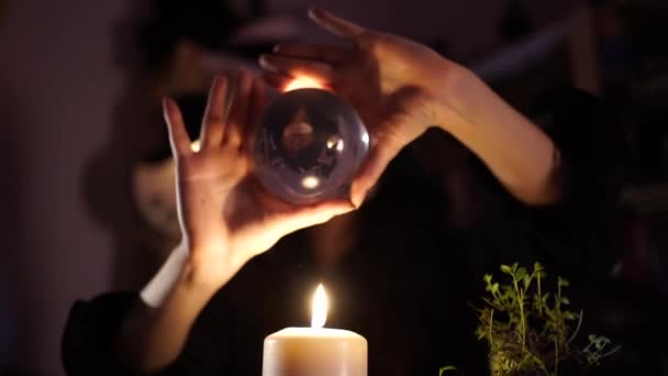 Divination on a crystal ball next to burning candles — Stock Video