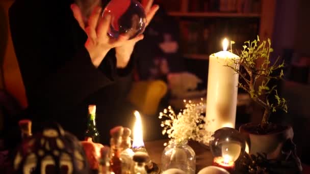 Divination on a crystal ball next to burning candles — Stock Video