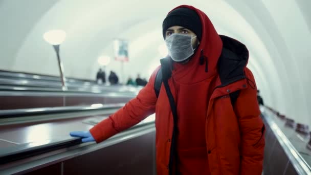 Man met masker en handschoenen daalt af in de metro — Stockvideo