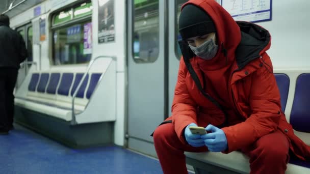 Mężczyzna o wyglądzie kaukaskim w masce i rękawiczkach jeździ metrem — Wideo stockowe