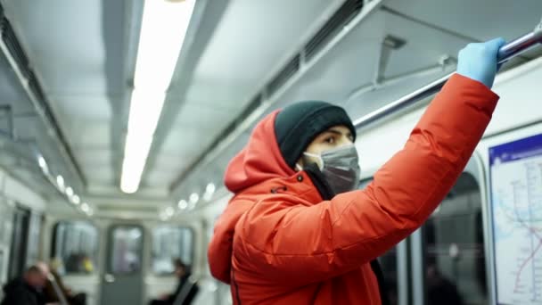 Mężczyzna o wyglądzie kaukaskim w masce i rękawiczkach jeździ metrem — Wideo stockowe