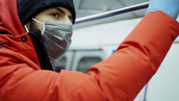 Un uomo di aspetto caucasico in maschera e guanti cavalca in un vagone della metropolitana — Video Stock