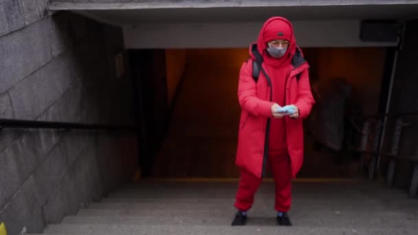 Een man in het rood draagt handschoenen in een tunnel. — Stockvideo