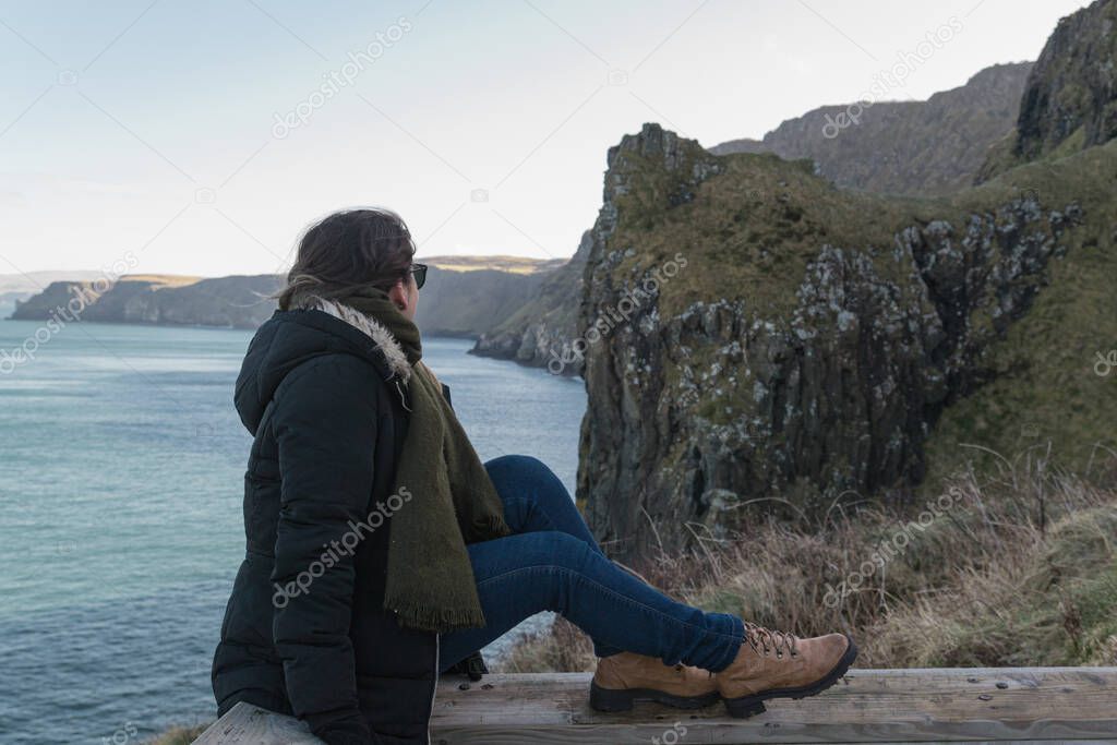 The girl enjoys the view of the cliffs of Northern Ireland.