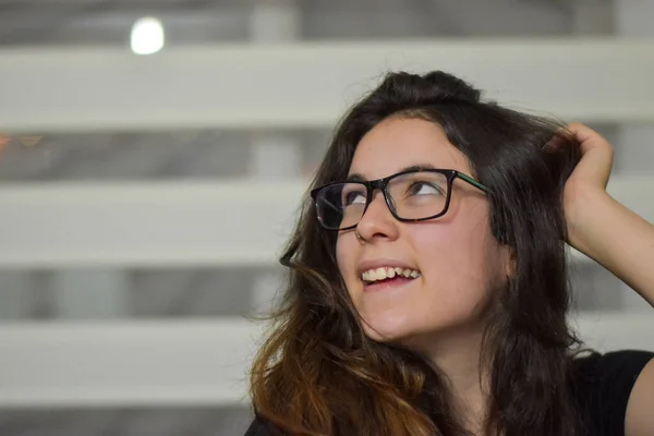 Gözlüklü ve siyah bluzlu güzel bir kız.