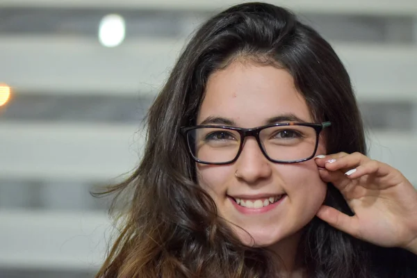 Gözlüklü ve siyah bluzlu güzel bir kız.