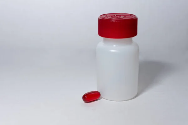 白色背景下的红色药丸和酒瓶 — 图库照片