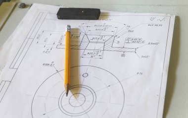 Sarı kalem ve çizimler, fabrikadaki metal bir masaya mıknatısla tutturulmuş.