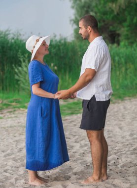 Çıplak ayaklı karı koca nehirde el ele tutuşuyorlar.