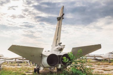Eski jet uçağı terk edilmiş bir havaalanında duruyor.