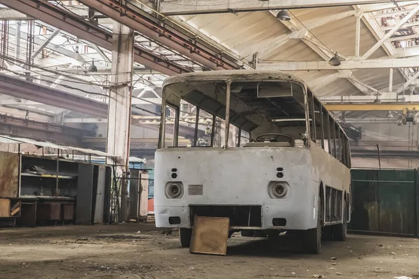 Terk edilmiş bir fabrikada eski parçalanmış bir otobüs.