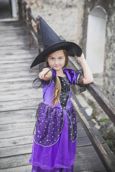young sorceress on the bridge in the castle conjuring by magic wand