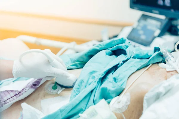 患者アジア高齢者女性 病院の集中治療室 Icu 部屋で患者のベッドの上の高齢者患者の腹部に超音波装置を使用しての医者によって診断のための腹部のスキャンを行う — ストック写真