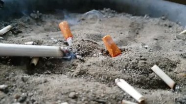 Açık havada küllük kum portre 4 k ile yanan sigara