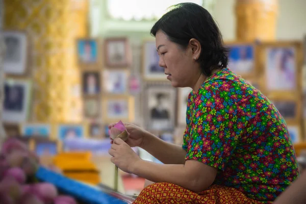 Thai buddhism people in buddhist pray for benefaction worship by incense and garland to Buddha or spirit-house at shrine or Thai temple (Wat Thai)