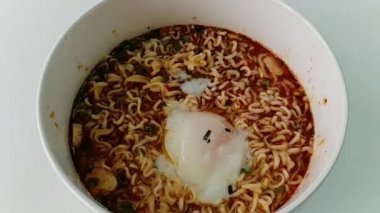 Ağır çekim bir anlık erişte ve beyaz kase içine koyun yumurta fastfood ve sağlıksız yiyecek ya da şişman kavramı olduğunu