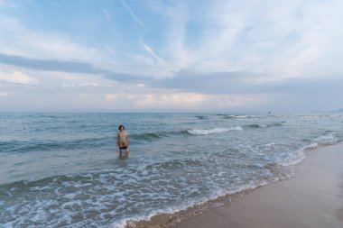 Mutlu kıvırcık saçlı Asyalı yaşlı kadın 60'ların seyahat ve denizde sakin ol ve ne zaman plaj tatil seyahat relax için