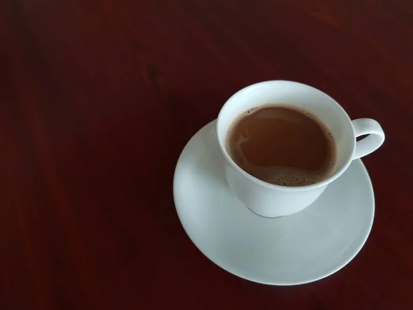 コーヒー ショップ カフェやレストランでお客様にサーブのためのお茶の木のテーブルの上の白いコーヒー カップでコーヒーを飲む — ストック写真