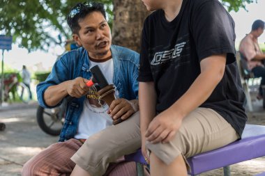 Bangkok, Tayland - 28 Temmuz 2017: hizmet Tay Masaj tedavi ağrı ve sancıları için tahta çekiç almaya kimliği belirsiz kadın Tay. Hizmetin açık bahçede geliyor.