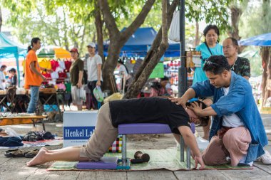 Bangkok, Tayland - 28 Temmuz 2017: hizmet Tay Masaj tedavi ağrı ve sancıları için tahta çekiç almaya kimliği belirsiz kadın Tay. Hizmetin açık bahçede geliyor.
