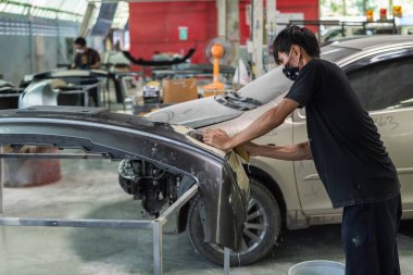 Bangkok, Tayland - 31 Ağustos 2017: Tanımlanamayan araba tamircisi veya asker denetlemek ve lif tampon vücut parçası yeni araba etek için araba garaj veya tamir dükkanında düzeltmek