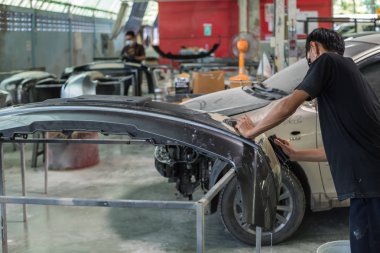 Bangkok, Tayland - 31 Ağustos 2017: Tanımlanamayan araba tamircisi veya asker denetlemek ve lif tampon vücut parçası yeni araba etek için araba garaj veya tamir dükkanında düzeltmek