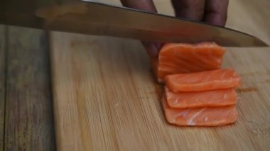 Asya Şef dilim somon çok taze çiğ Somon Balık Japon lokantasında dilimlenmiş turp ile hizmet veren ince parçalar halinde dilimlenmiş balığı somon oluşan Japon yemekleri incelik için Danışma üzerinde bıçak tarafından