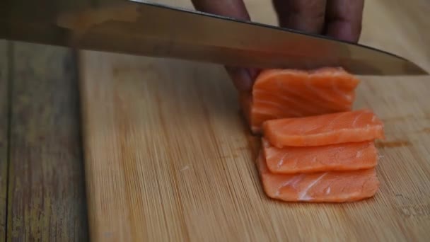 日本食レストランでスライスした大根であり薄片にスライスした非常に新鮮な生のサーモン ピンクの魚の刺身サーモンで構成される日本料理の繊細さのボード上にナイフでアジア シェフ スライス サーモン — ストック動画