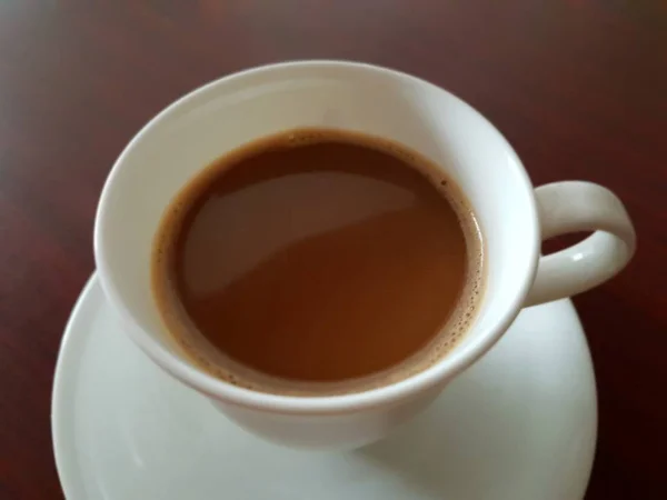 コーヒー ショップ カフェやレストランでお客様にサーブのためのお茶の木のテーブルの上の白いコーヒー カップでコーヒーを飲む — ストック写真