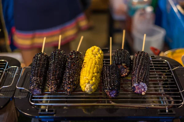 Roasted or Grilled Corn and Purple Corn (Black Glutinous Corn) for sale at Thai street food market or restaurant in Thailand