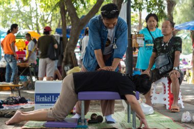 Bangkok, Tayland - 28 Temmuz 2017: hizmet Tay Masaj tedavi ağrı ve sancıları için tahta çekiç almaya kimliği belirsiz kadın Tay. Hizmetin açık bahçede geliyor.