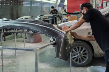 Bangkok, Tayland - 31 Ağustos 2017: Tanımlanamayan araba tamircisi veya asker denetlemek ve lif tampon vücut parçası yeni araba etek için araba garaj veya tamir dükkanında düzeltmek