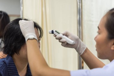 Bangkok, Tayland - 29 Haziran 2018: Tanımlanamayan Taylandlı kadın sağlık onay ölçü ateş dijital kızılötesi termometre tarafından her yıl Hastanesi Sağlık Bakanlığı tarafından düzeyleri.
