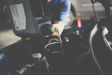 Araba tamircisi veya asker bir taze yağ motor yağı araç garaj, onarım veya bakım için bir araba doldurur